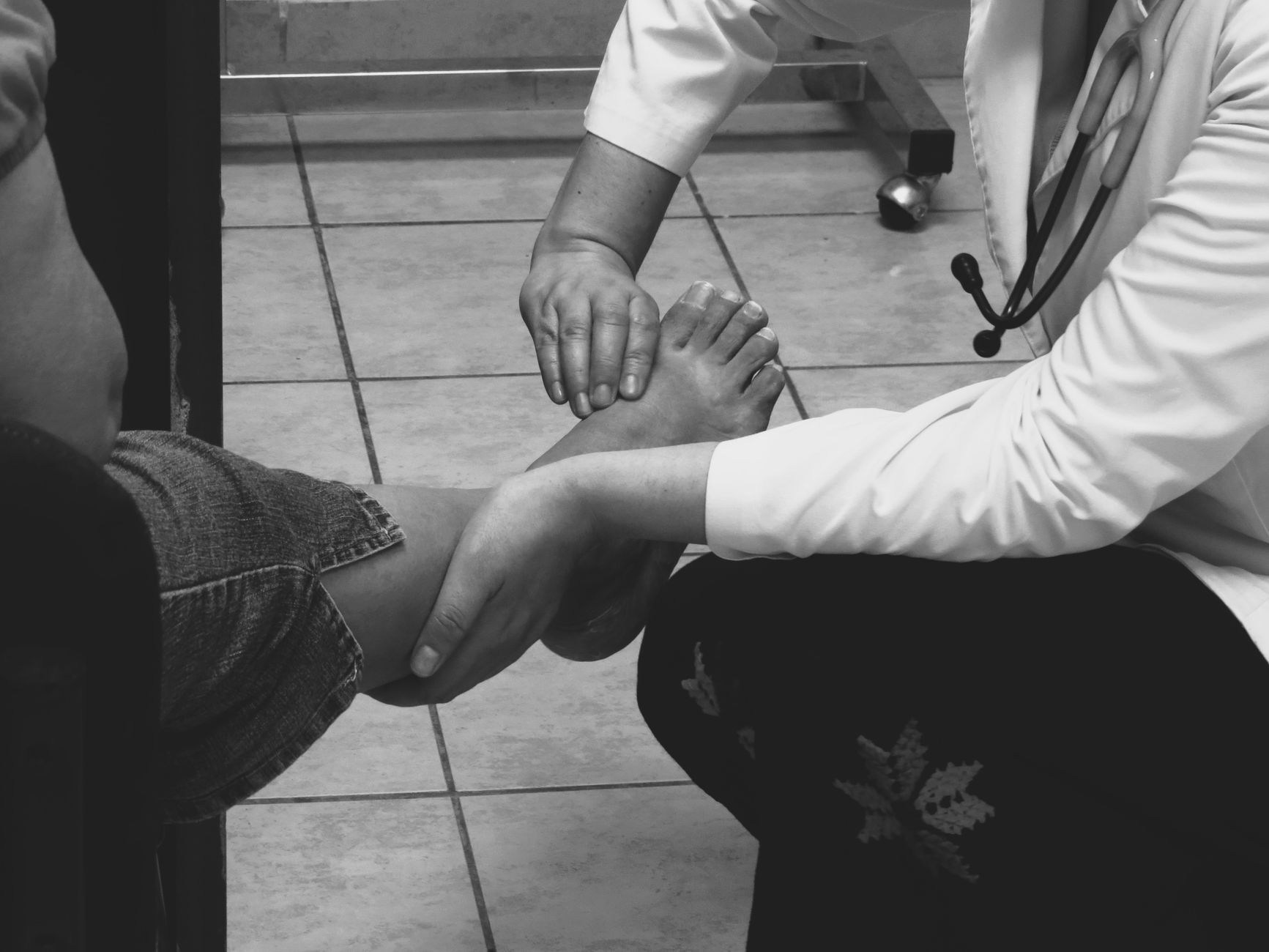 Podiatrist examining a patient's foot during a consultation, the kind of visit that starts as a Google symptom search