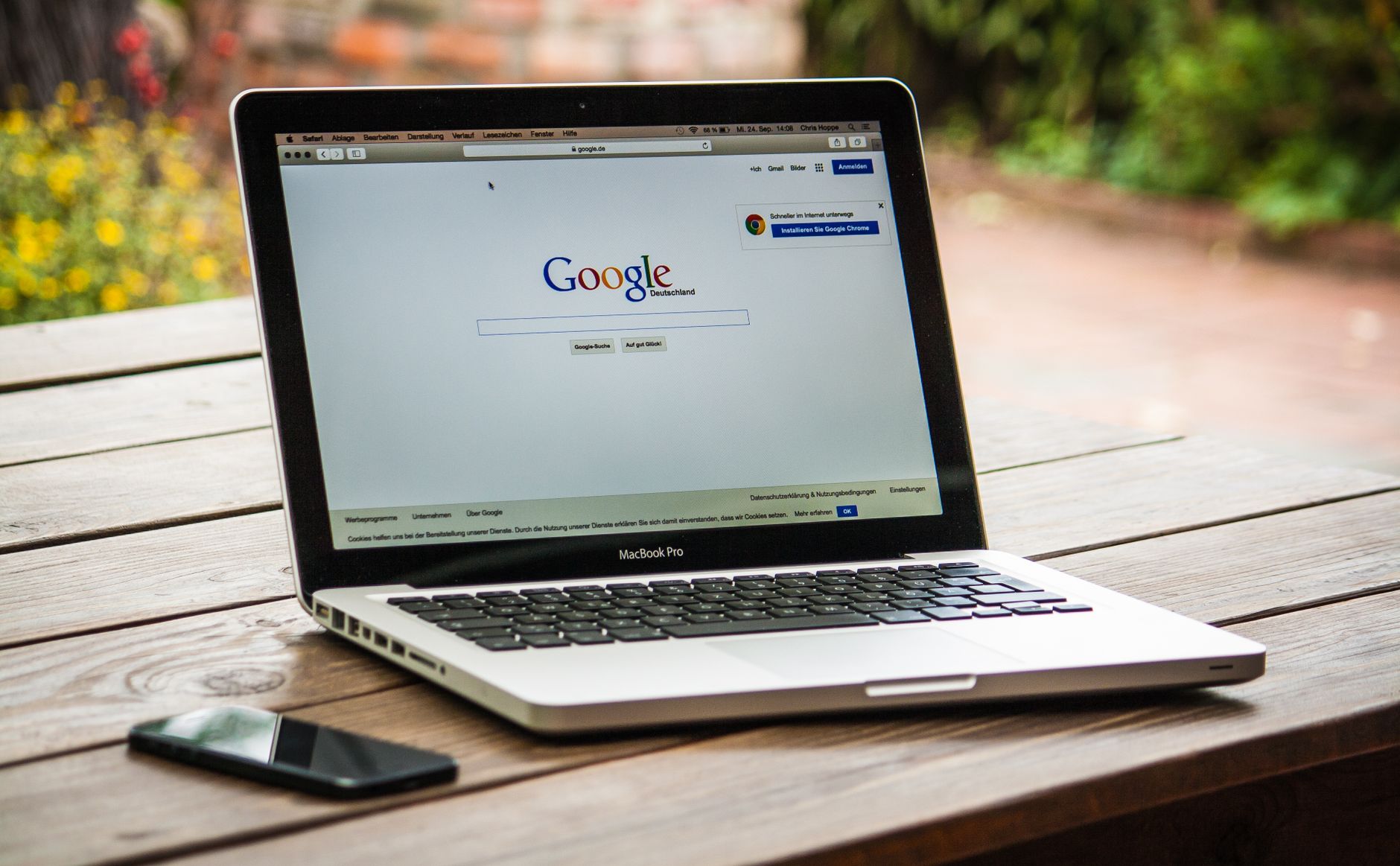 A laptop open to Google search on a wooden table, representing a homeowner researching garage door repair