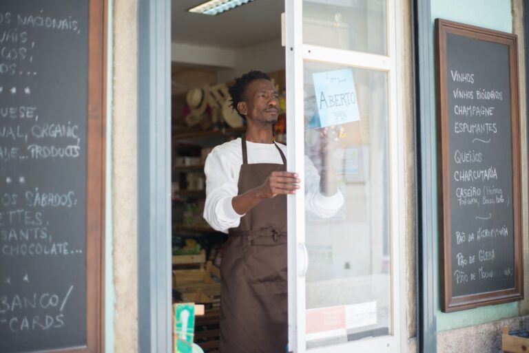Local shop owner opening his storefront and hanging the open sign