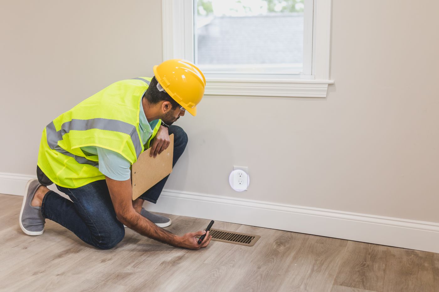 HVAC contractor inspecting home vent during a local service call