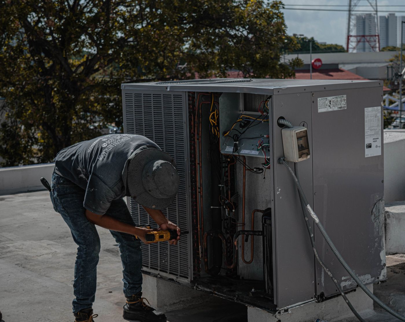 HVAC technician servicing a rooftop commercial air conditioning unit