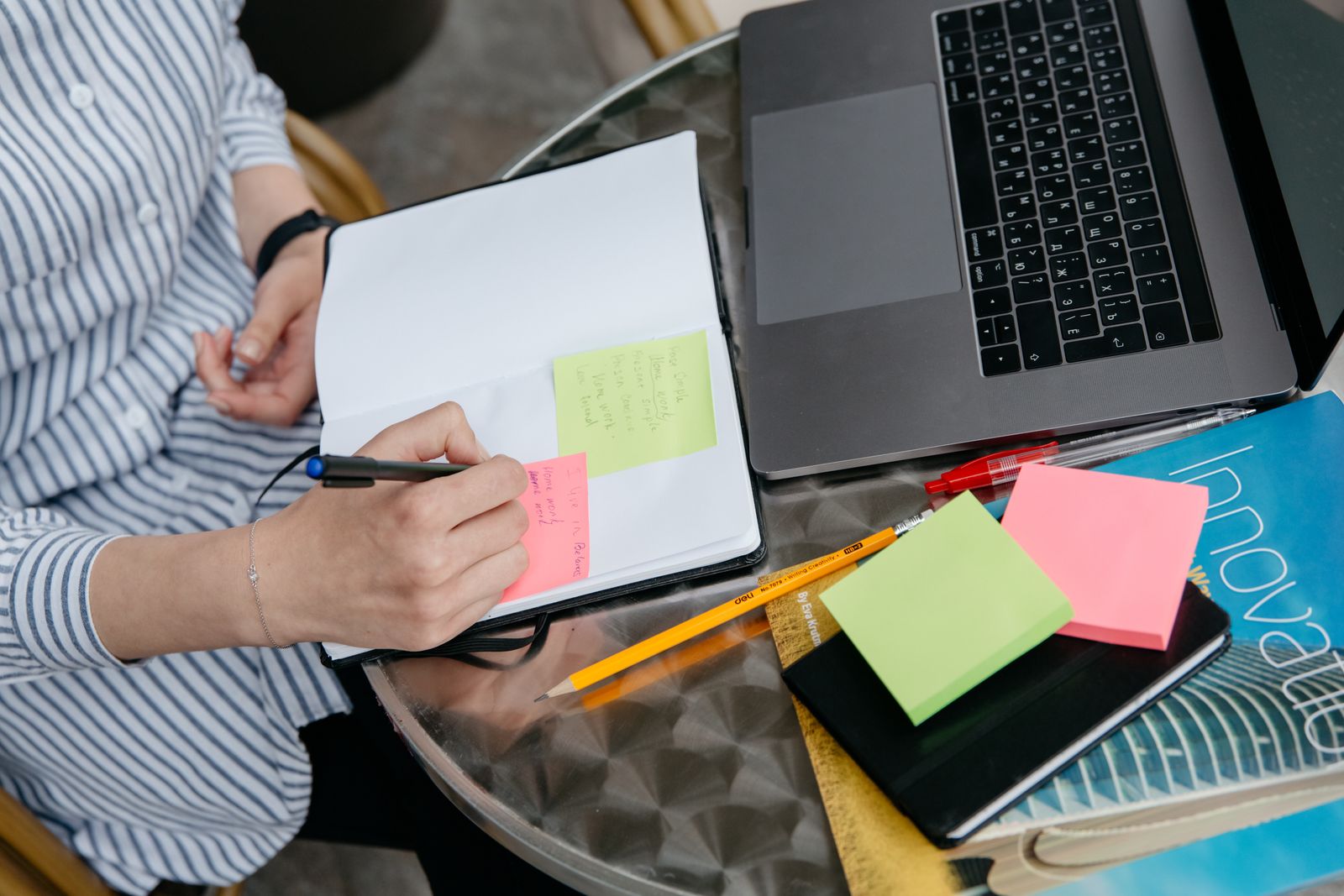 Business owner planning a content list with sticky notes beside a laptop