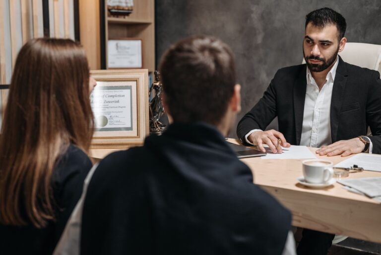 Immigration lawyer meeting with clients across a desk in a professional law office