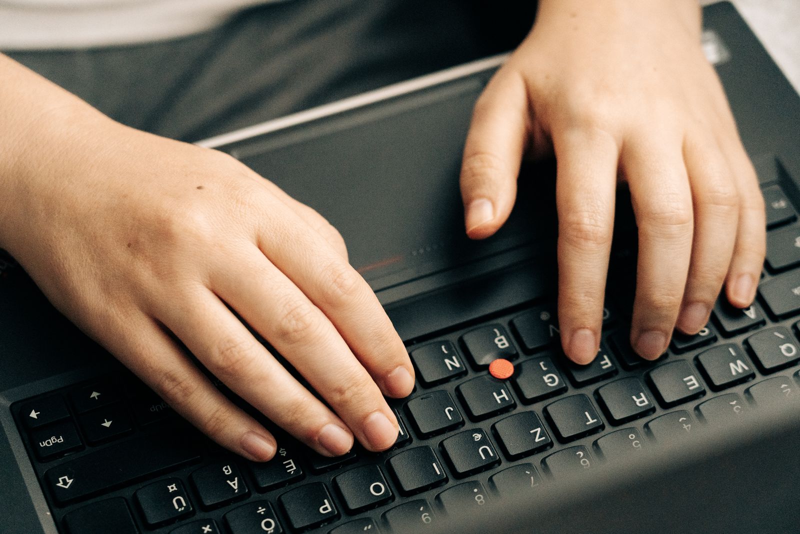 Close-up of hands editing an article draft on a laptop keyboard