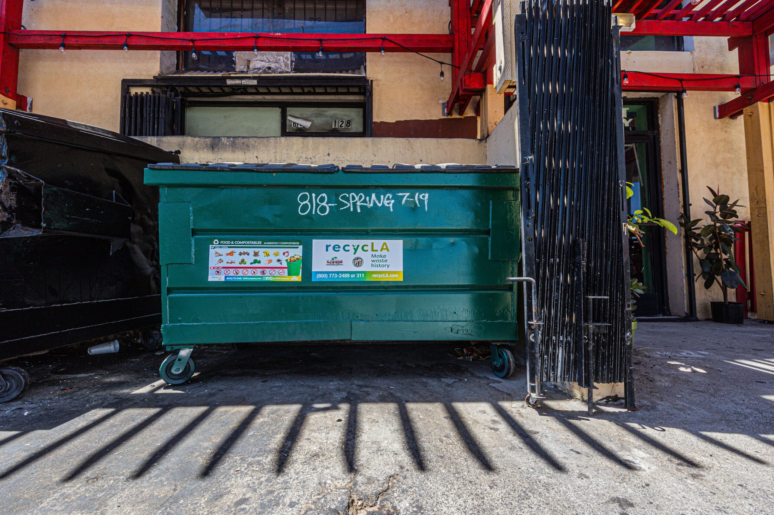 A commercial dumpster behind a business, a recurring junk removal account