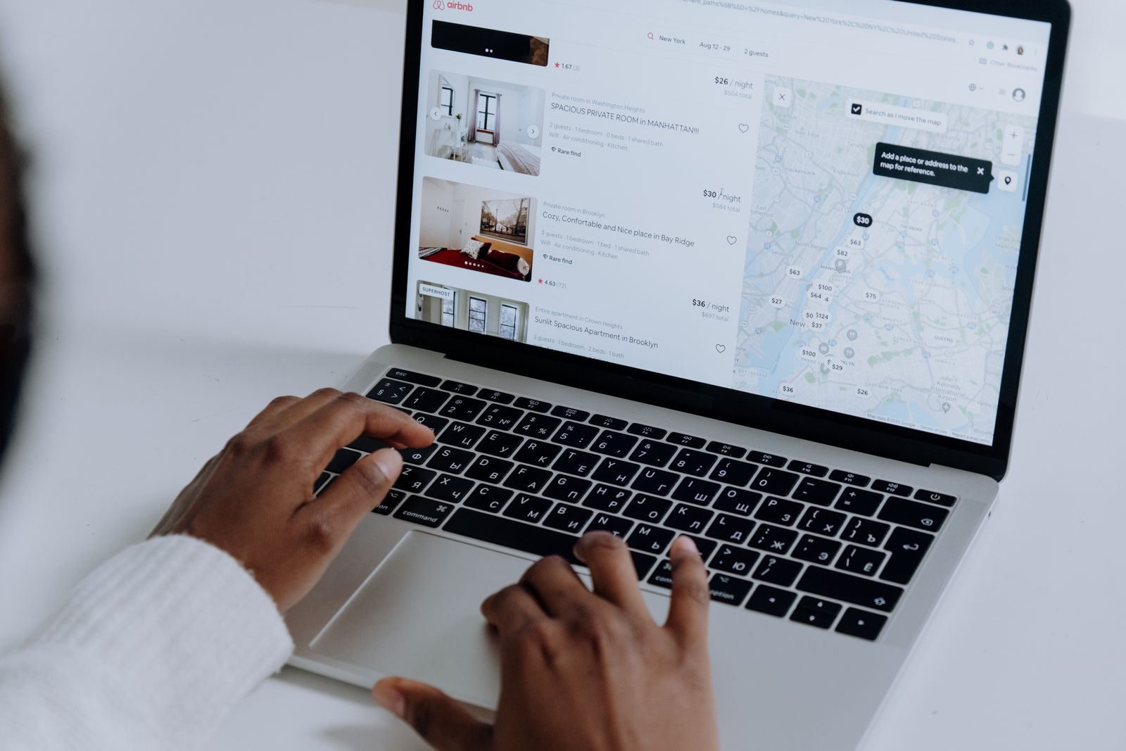 Customer comparing local businesses on a laptop with a map of listings and prices