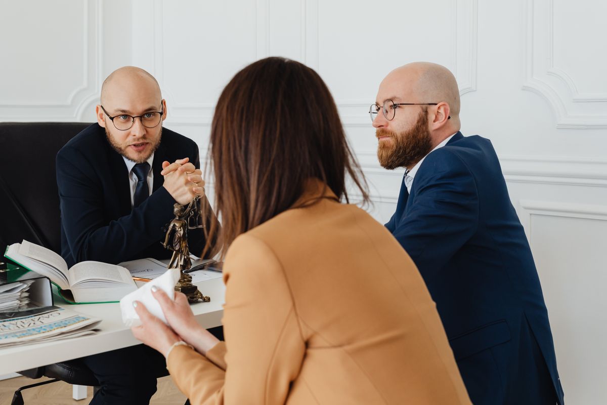 Attorney consulting with clients at a law firm office, reviewing case documents