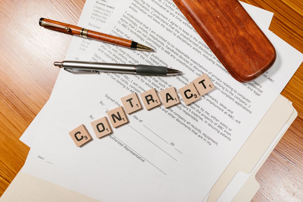 Legal contract documents with pen on a desk, representing client acquisition and signed retainers