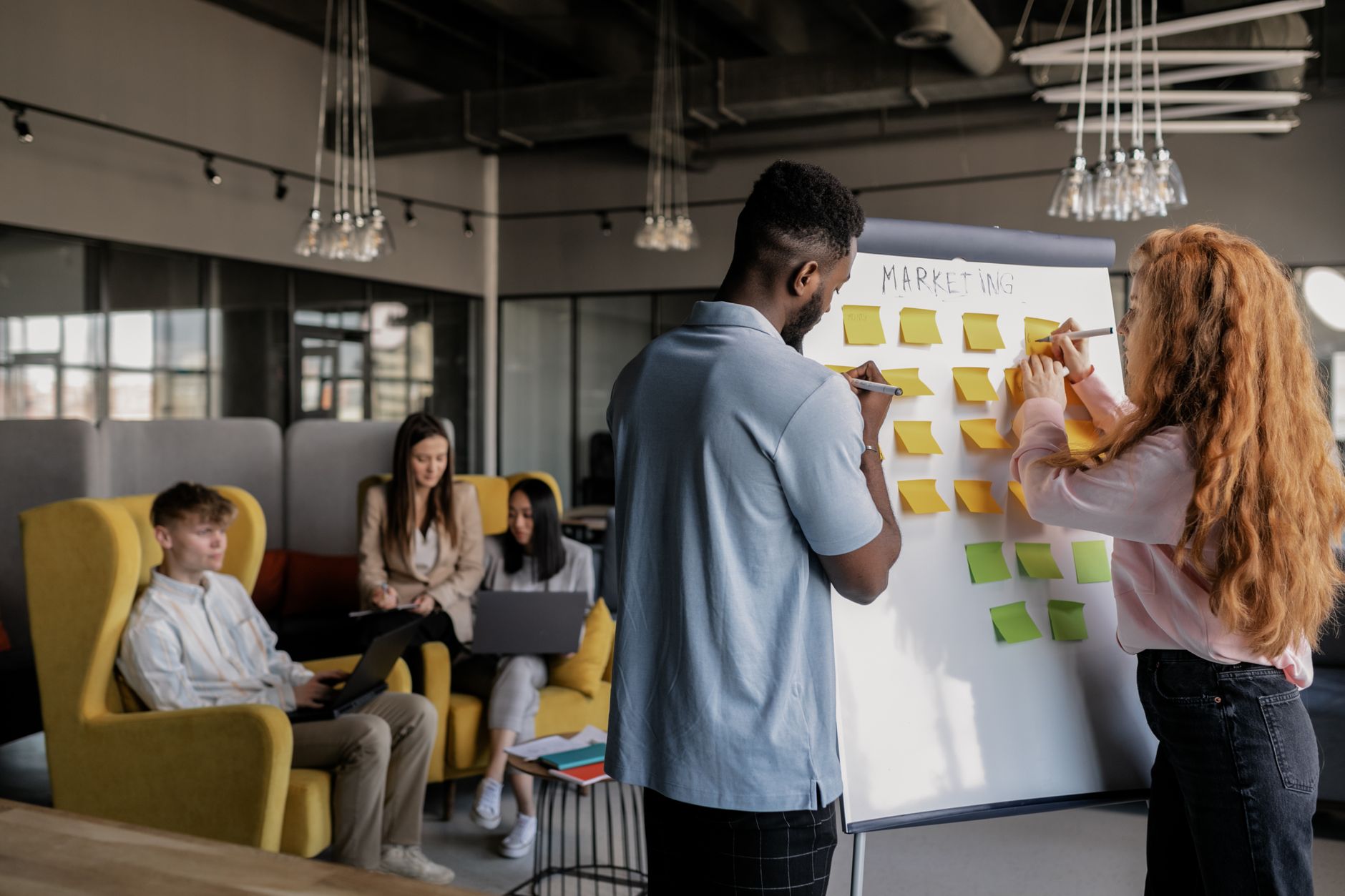 A small business team planning blog topics and keywords on a wall of sticky notes