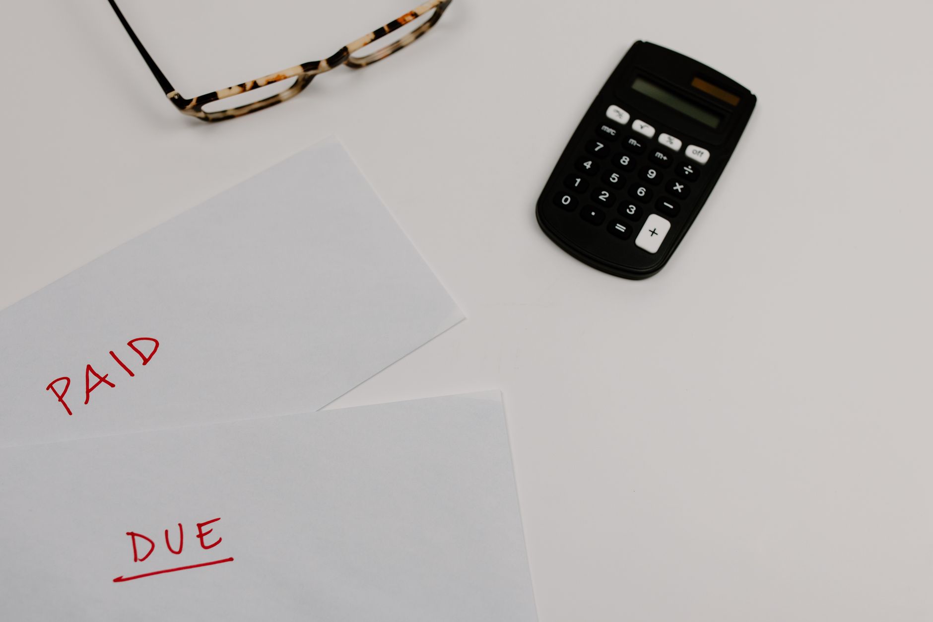 Envelopes marked paid and due beside a calculator, showing the medical costs behind an injury claim