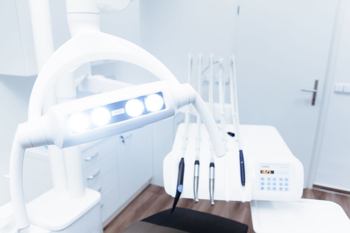 Modern dental treatment room with examination chair, LED surgical light, and dental equipment