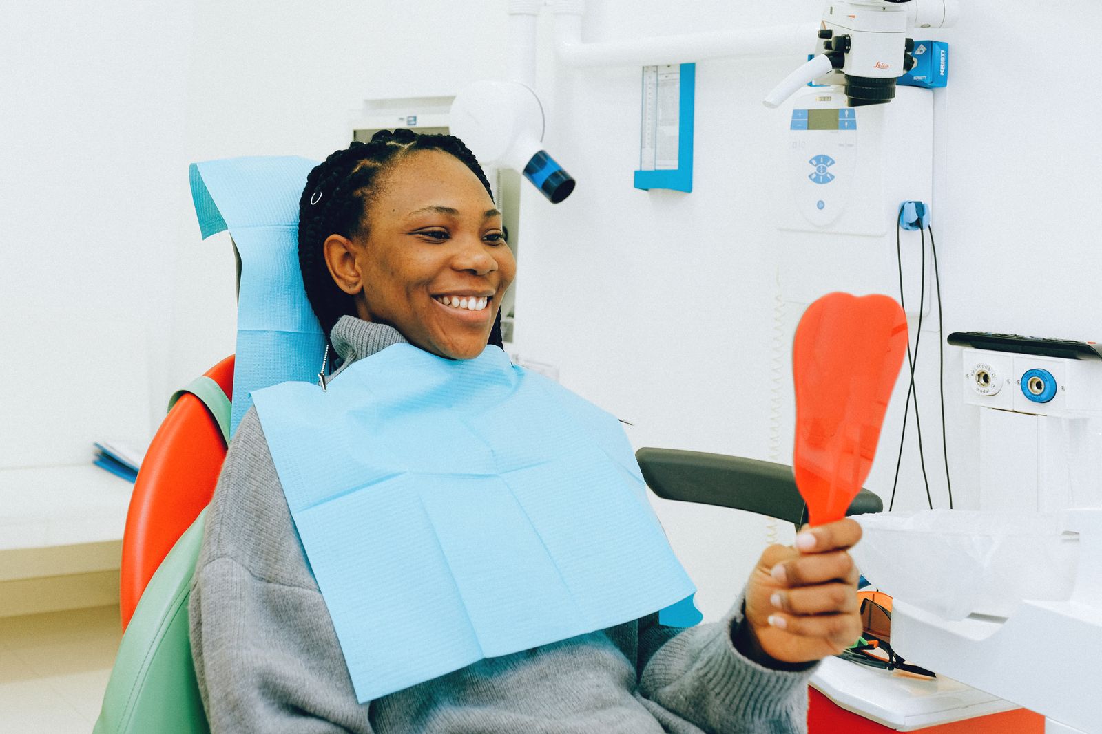 Smiling patient holding a mirror after a cosmetic dental treatment