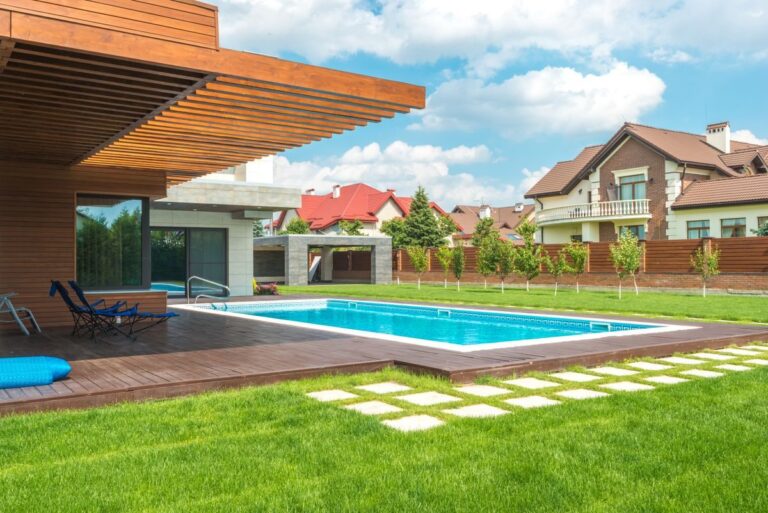 SEO for pool companies — modern backyard swimming pool behind a suburban home