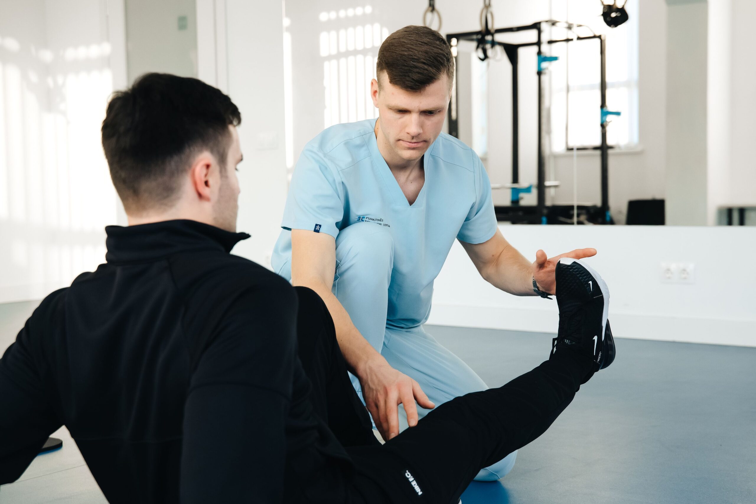 Physiotherapist guiding a patient through leg rehabilitation exercises