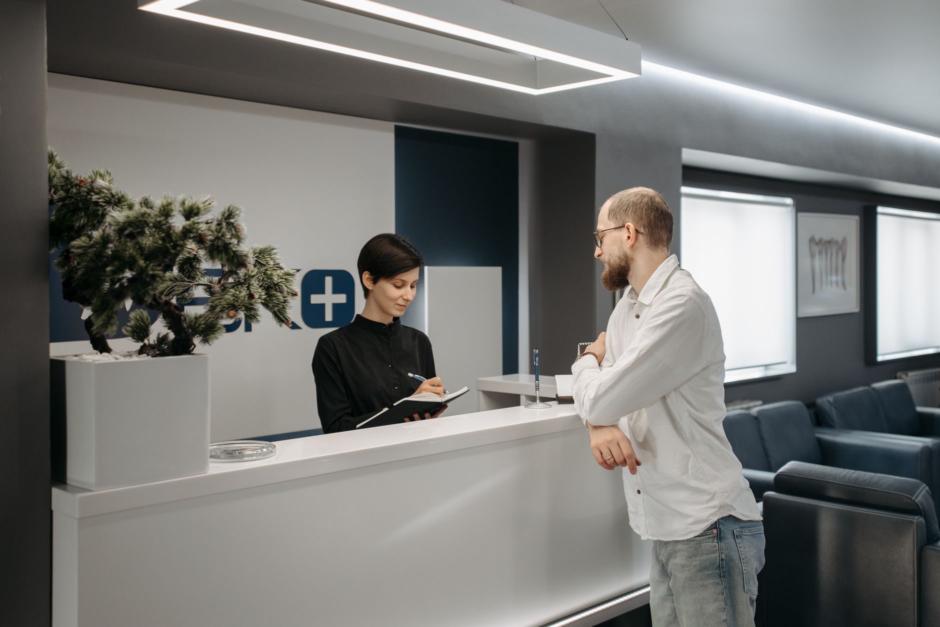 Patient checking in at a podiatry clinic reception desk after finding the practice through a Google search