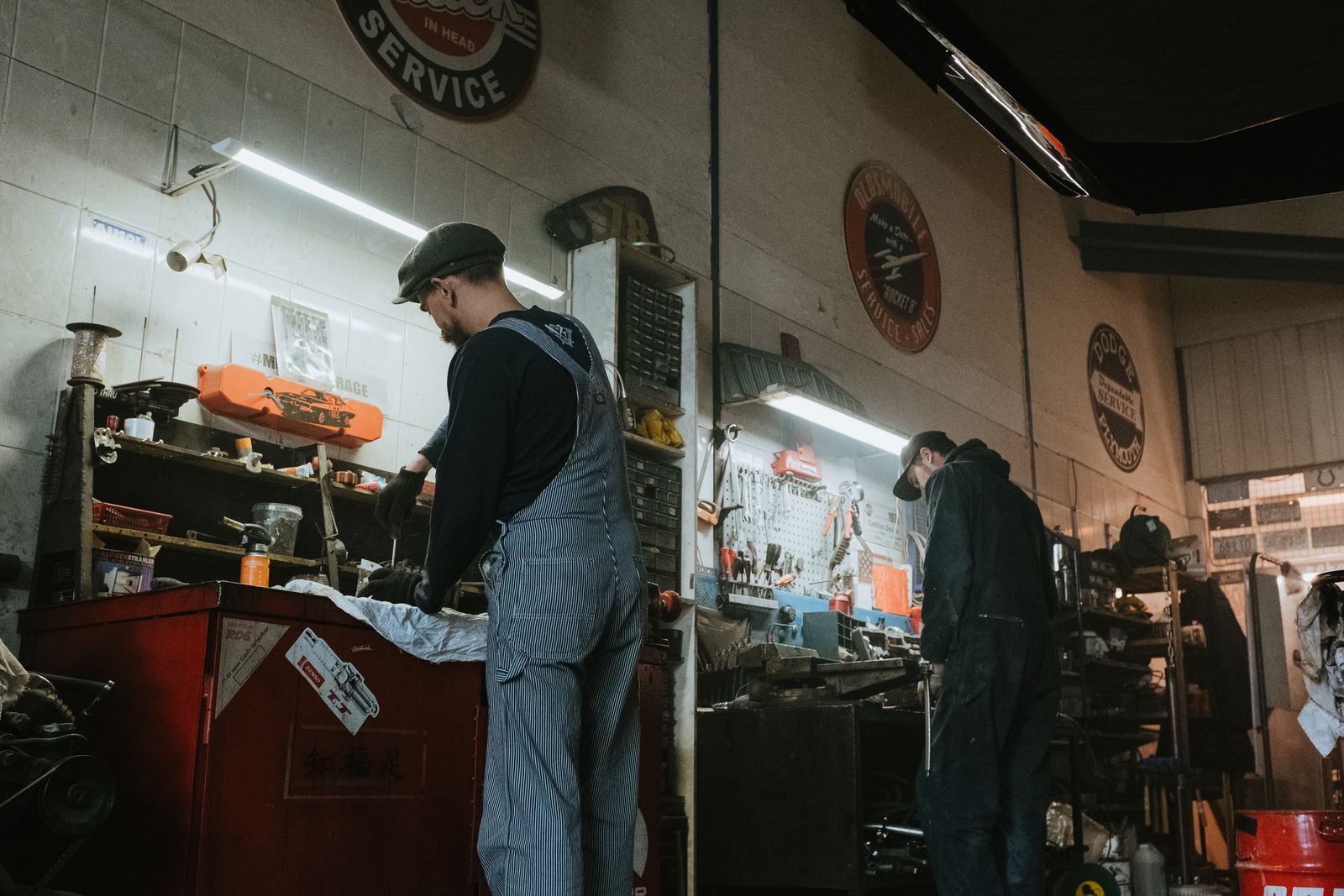 Two mechanics working at benches inside an independent service garage
