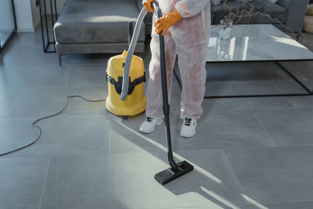 Professional cleaner vacuuming a modern living room floor during a deep cleaning service appointment