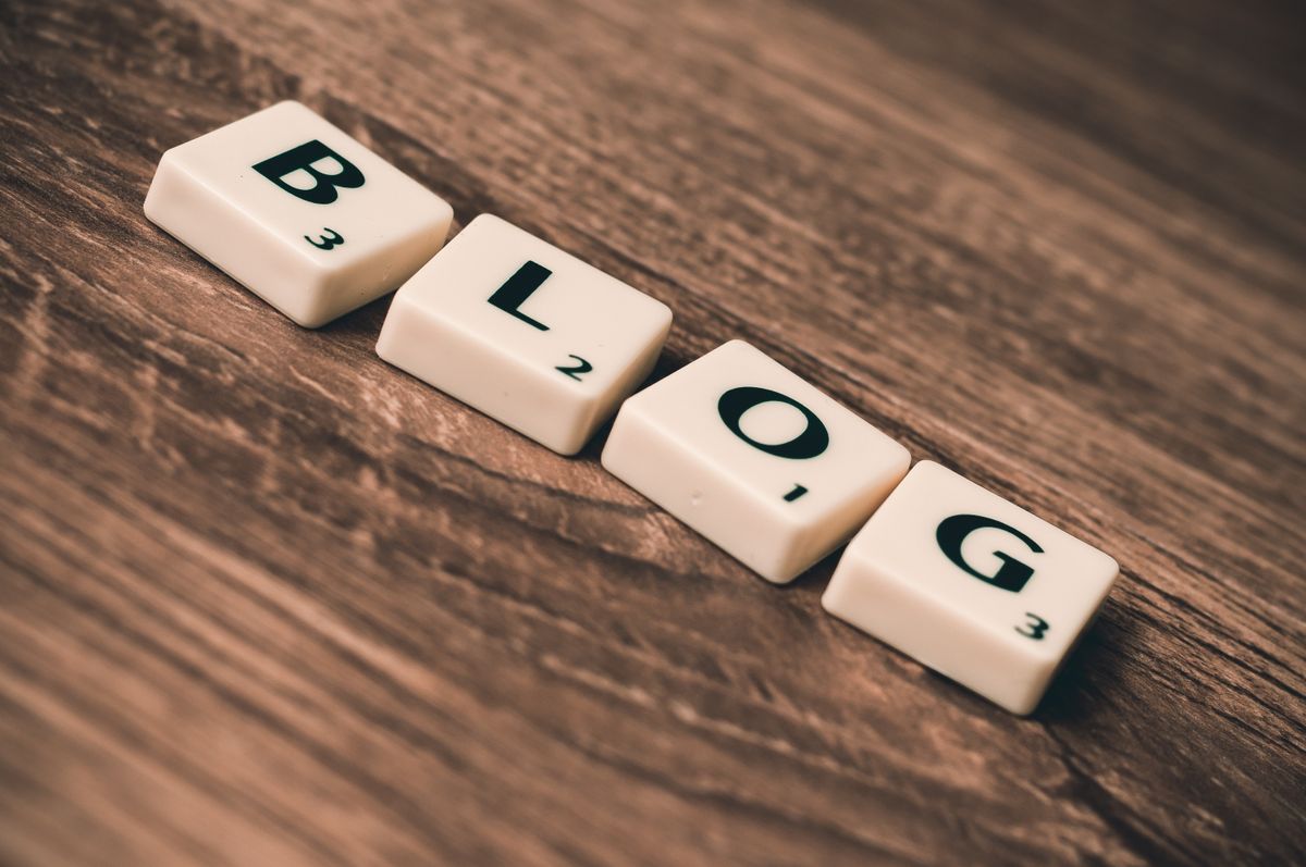 Wooden letter tiles spelling BLOG on a table representing content creation strategy