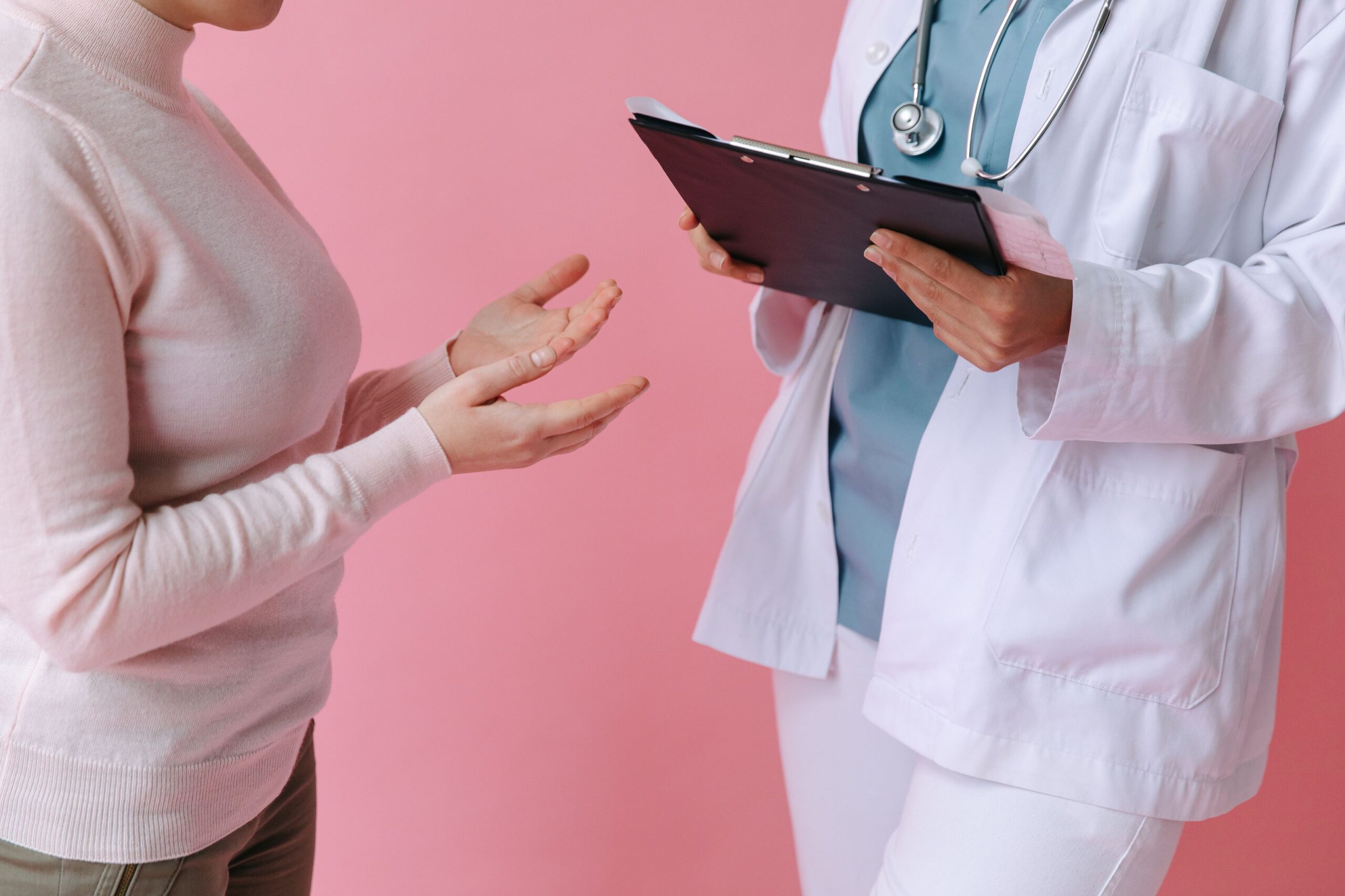 Plastic surgeon holding a clipboard and discussing a treatment plan with a patient