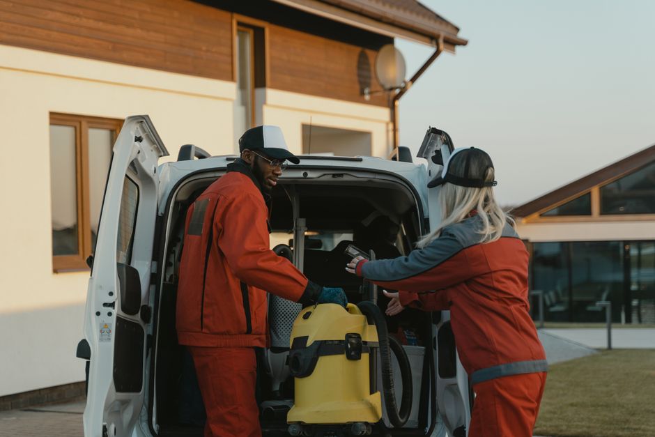 A restoration crew loading extraction equipment into a service van