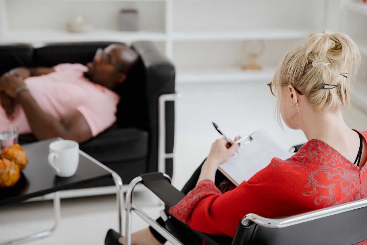 psychologist with client lying on therapy couch during counseling session