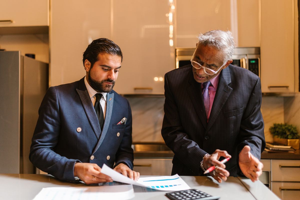 Two wealth management professionals reviewing client financial portfolio documents together