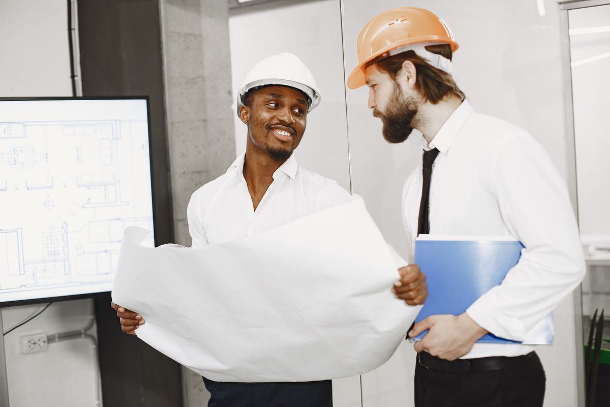 Two contractors reviewing project blueprints and planning a home renovation