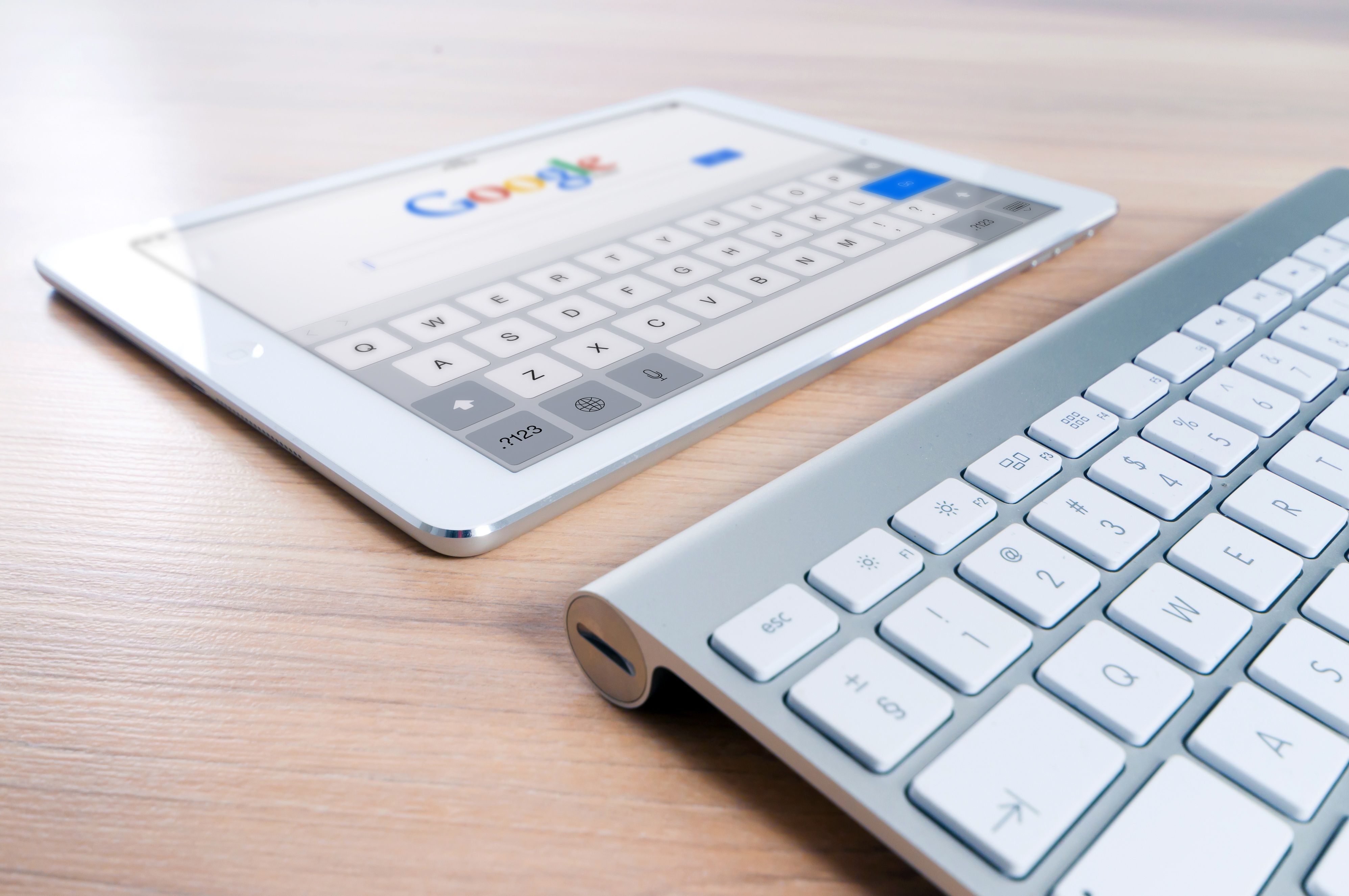 Google search home screen displayed on a tablet next to a wireless keyboard