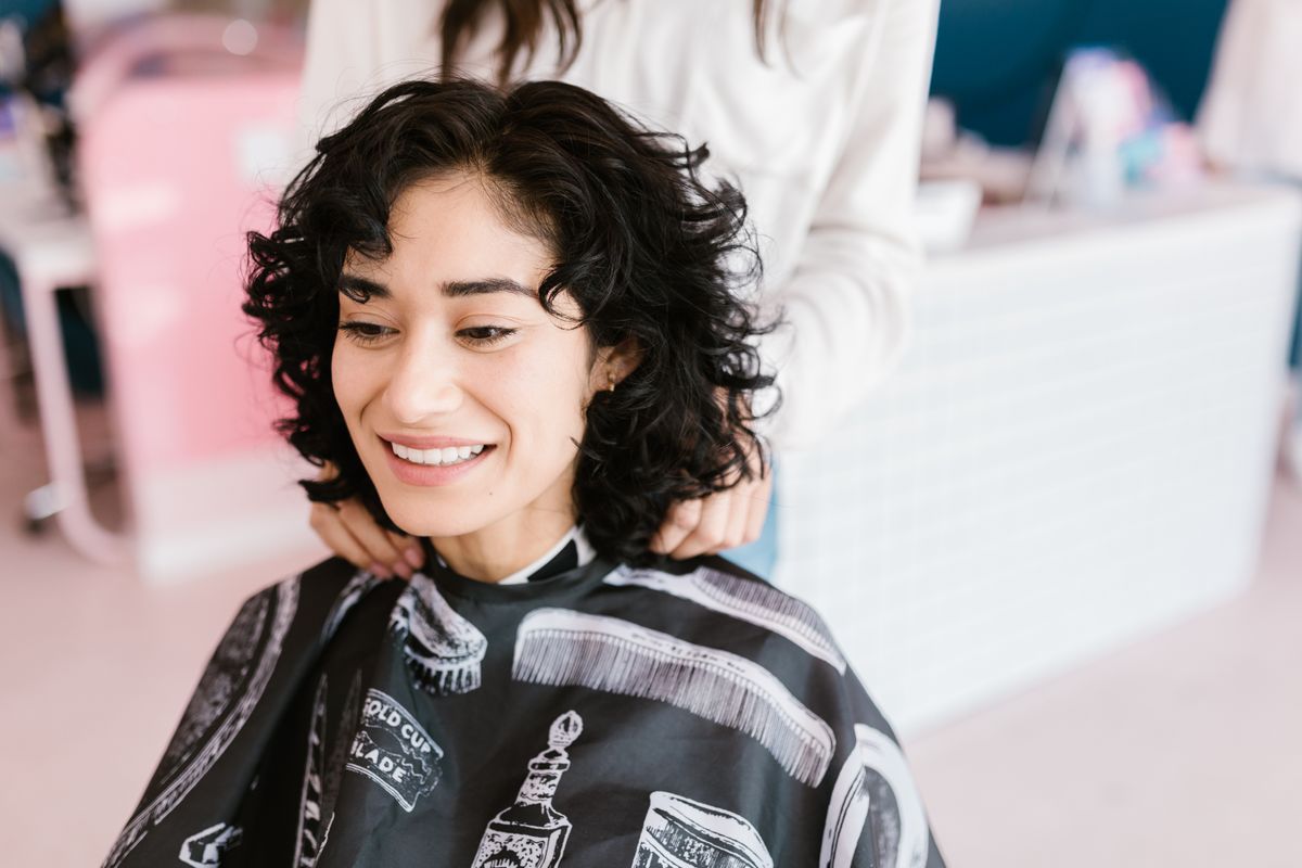 Happy hair salon client smiling after a fresh haircut in a modern salon