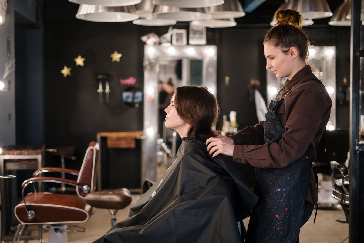 Hairstylist carefully working on a client in a well-lit hair salon