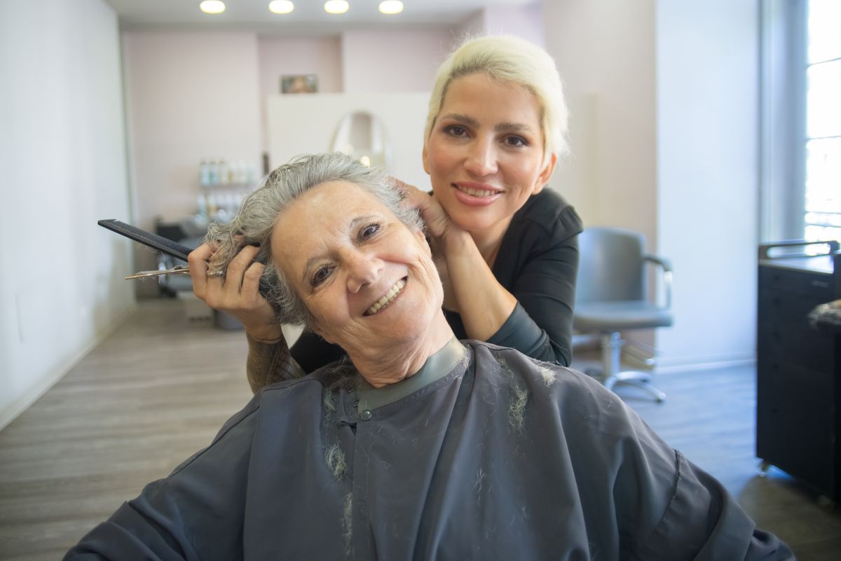 Hair salon stylist and client sharing a warm moment after a successful styling session