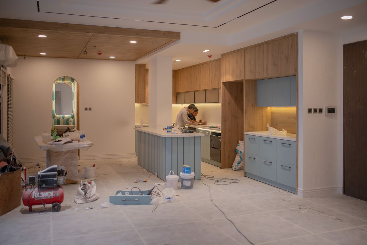 Kitchen contractor installing cabinetry during a mid-renovation remodel project