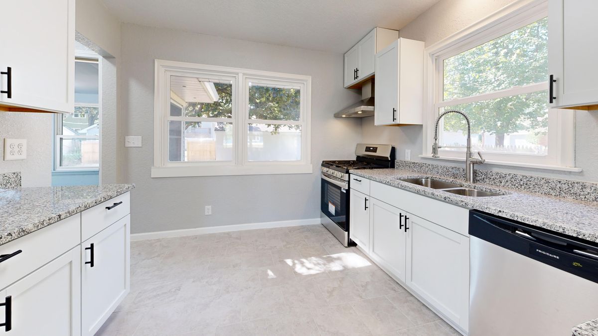 Sunlit modern kitchen with granite countertops after a professional full remodel