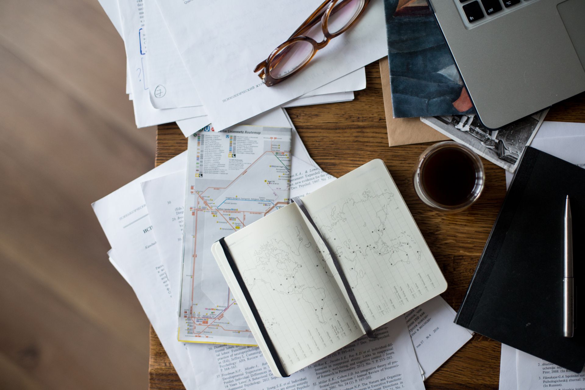 Desk covered with printed maps and open notebook for planning service routes