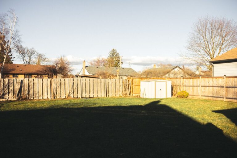 Residential backyard with wooden privacy fence and manicured lawn