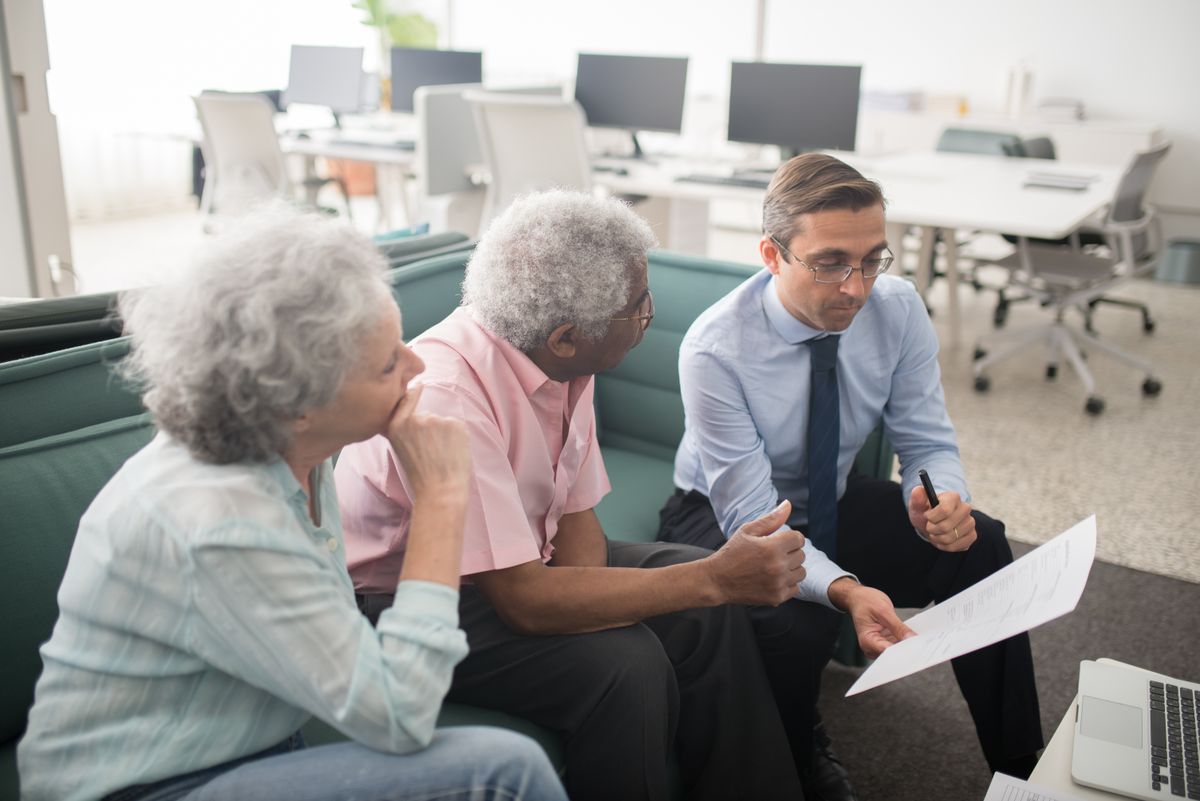 Senior couple reviewing estate planning documents with their attorney — older adults who research attorneys on Google before calling are the most qualified leads