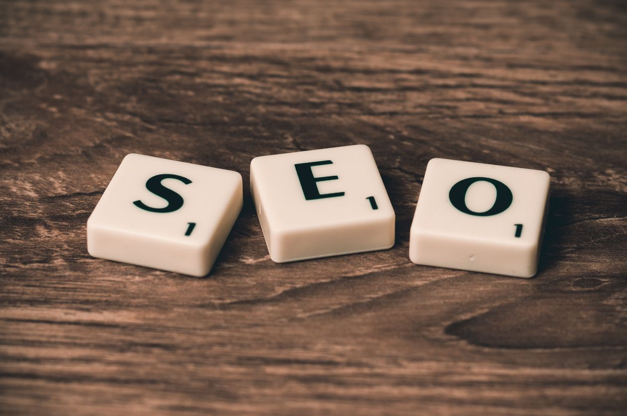 SEO spelled out in Scrabble letter tiles on a wooden surface