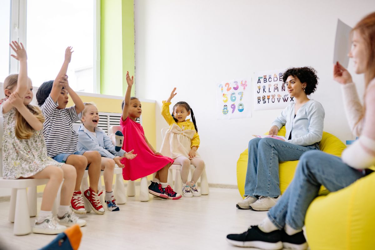 Daycare teacher working with young children in a bright, welcoming classroom