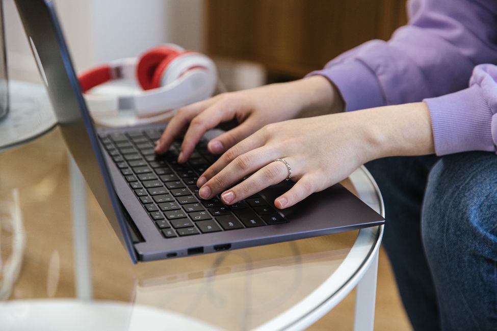 Hands typing on a laptop, writing blog content