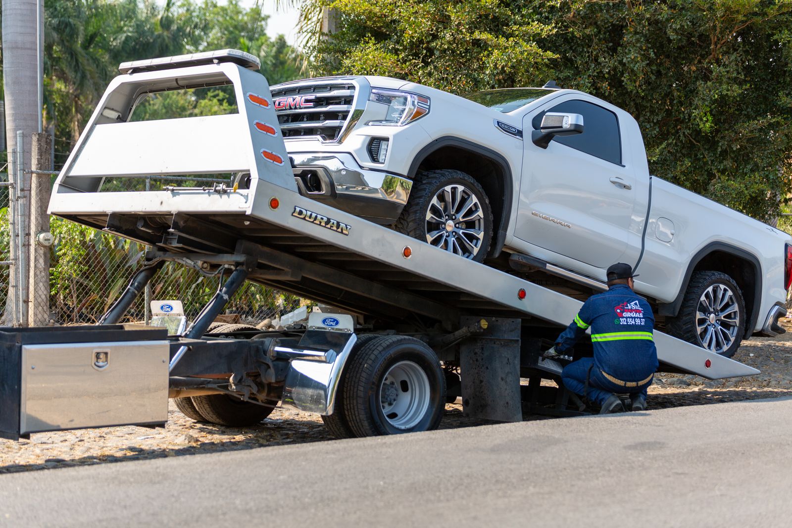 Tow truck operator loading a vehicle onto a flatbed — a real photo supporting SEO for towing companies