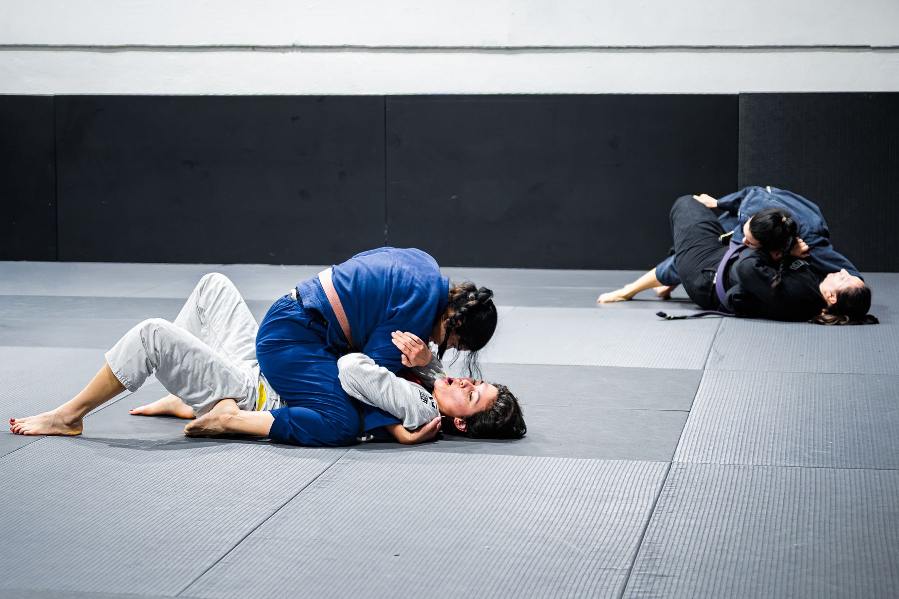 Students training on the mats inside a martial arts studio