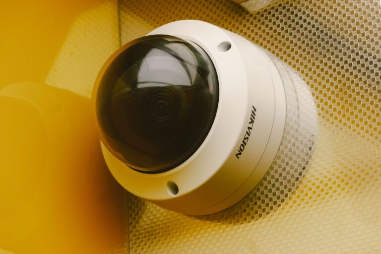 Technician installing a security camera on a building exterior for surveillance