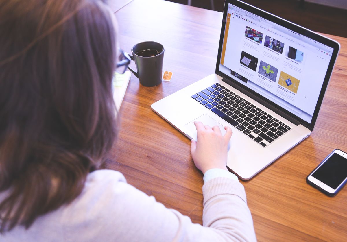Person researching local press opportunities for link building on a MacBook at a desk