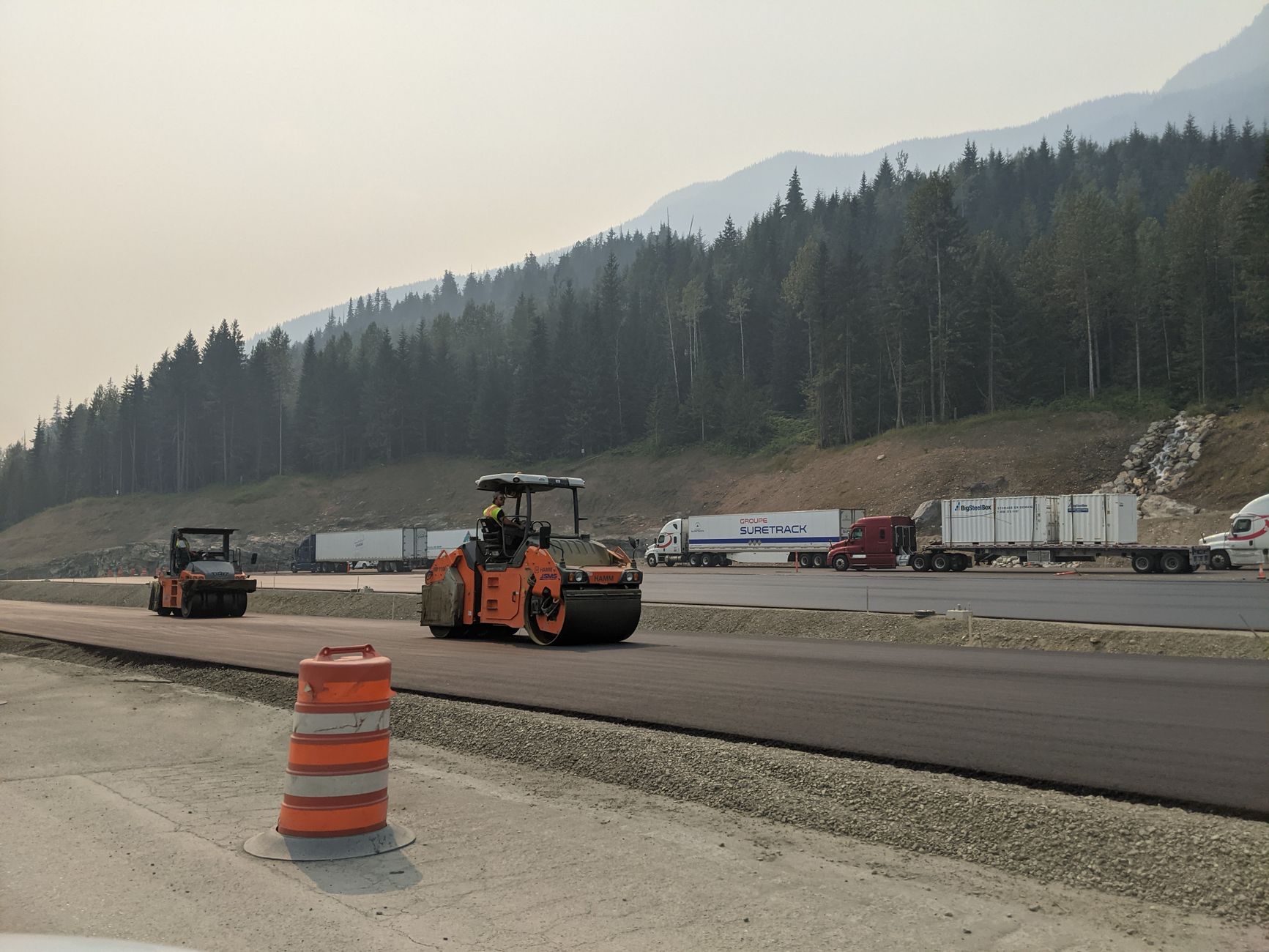 Paving crew operating equipment during an asphalt driveway installation