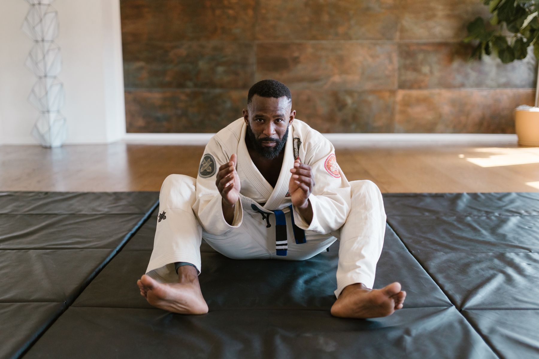 Two students practicing jiu-jitsu technique on the mats