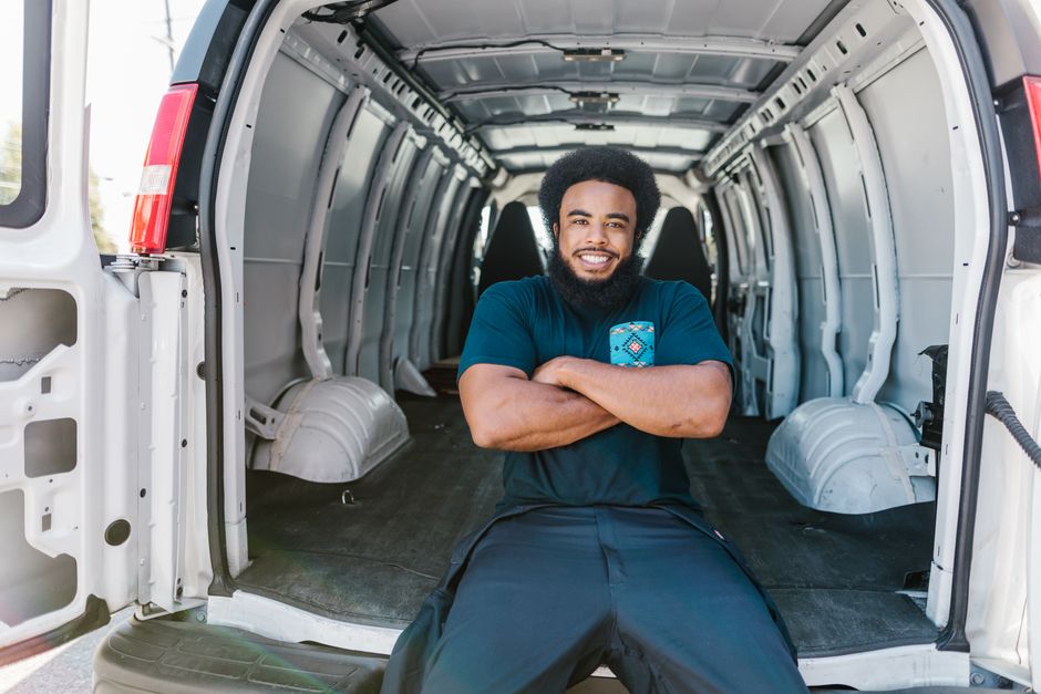 Mobile detailing technician standing in the back of his service van