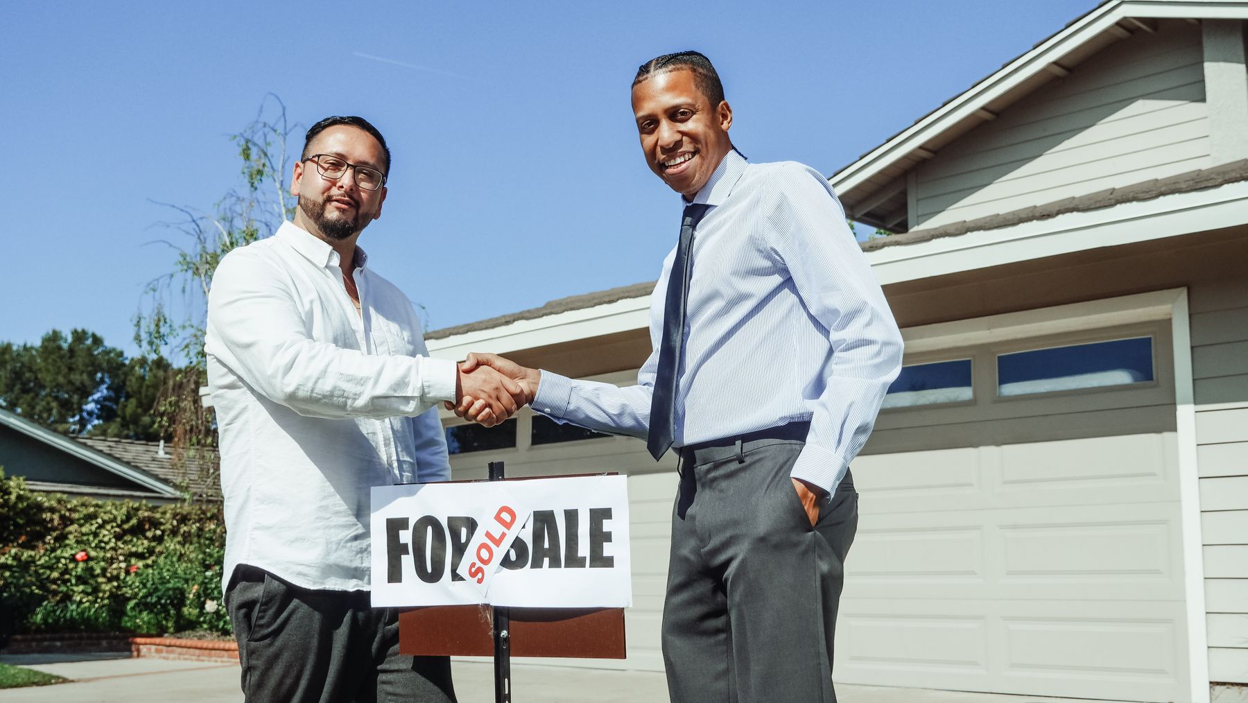 Homeowner and contractor shaking hands outside a house after agreeing on a foundation repair estimate