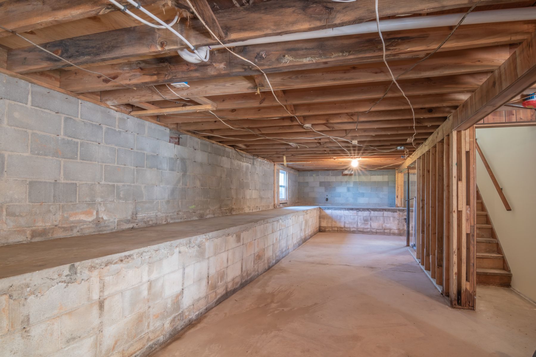Empty unfinished basement with concrete foundation walls, the kind of space homeowners inspect after noticing cracks