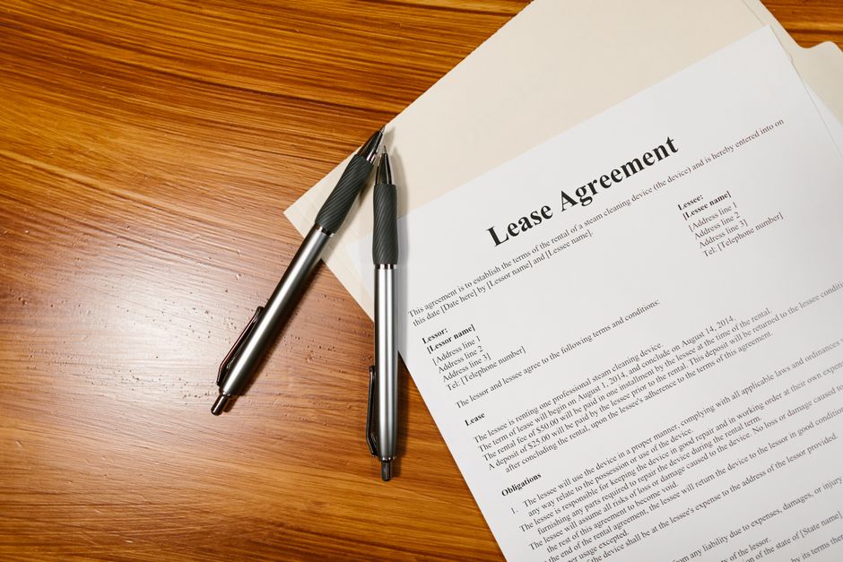 Lease agreement document on a desk with two pens