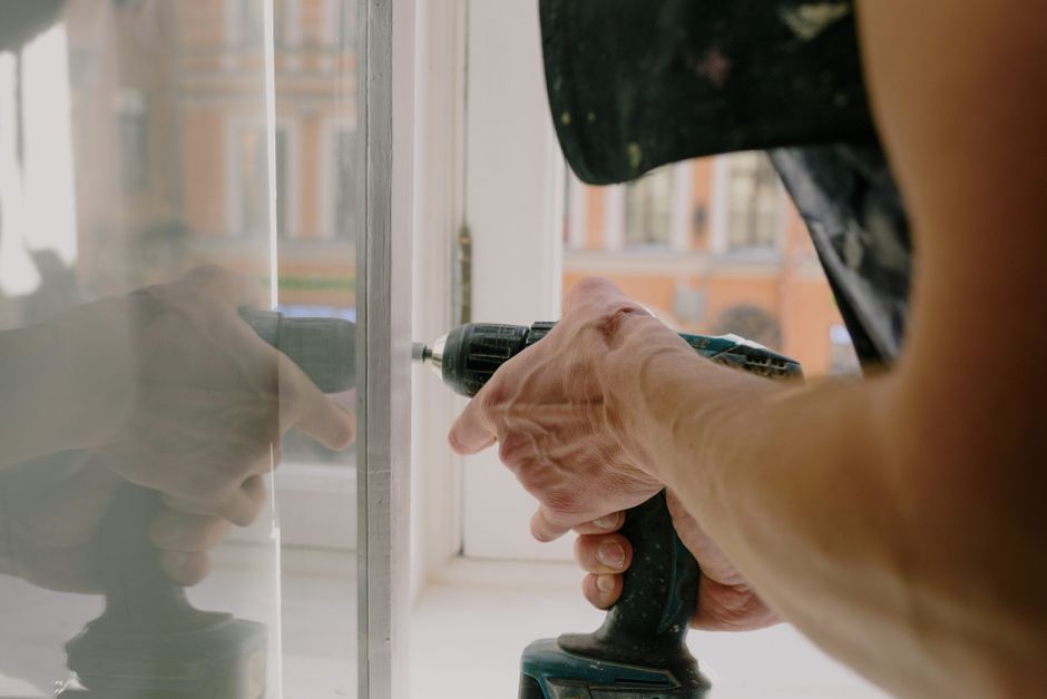 Maintenance worker repairing a window frame in an apartment building